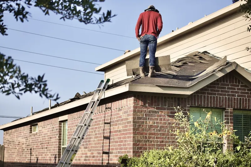 Professional roofer working on a residential roof in Riego